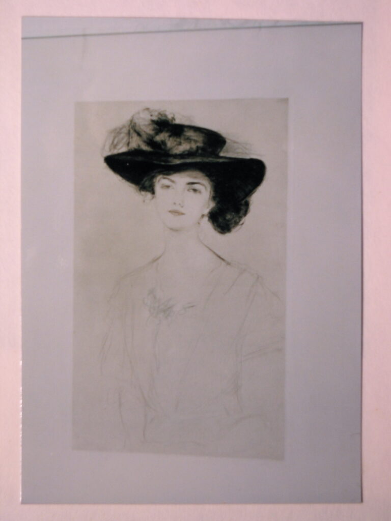 An old portrait of a woman wearing a large hat with a feather, displayed in a simple rectangular frame.